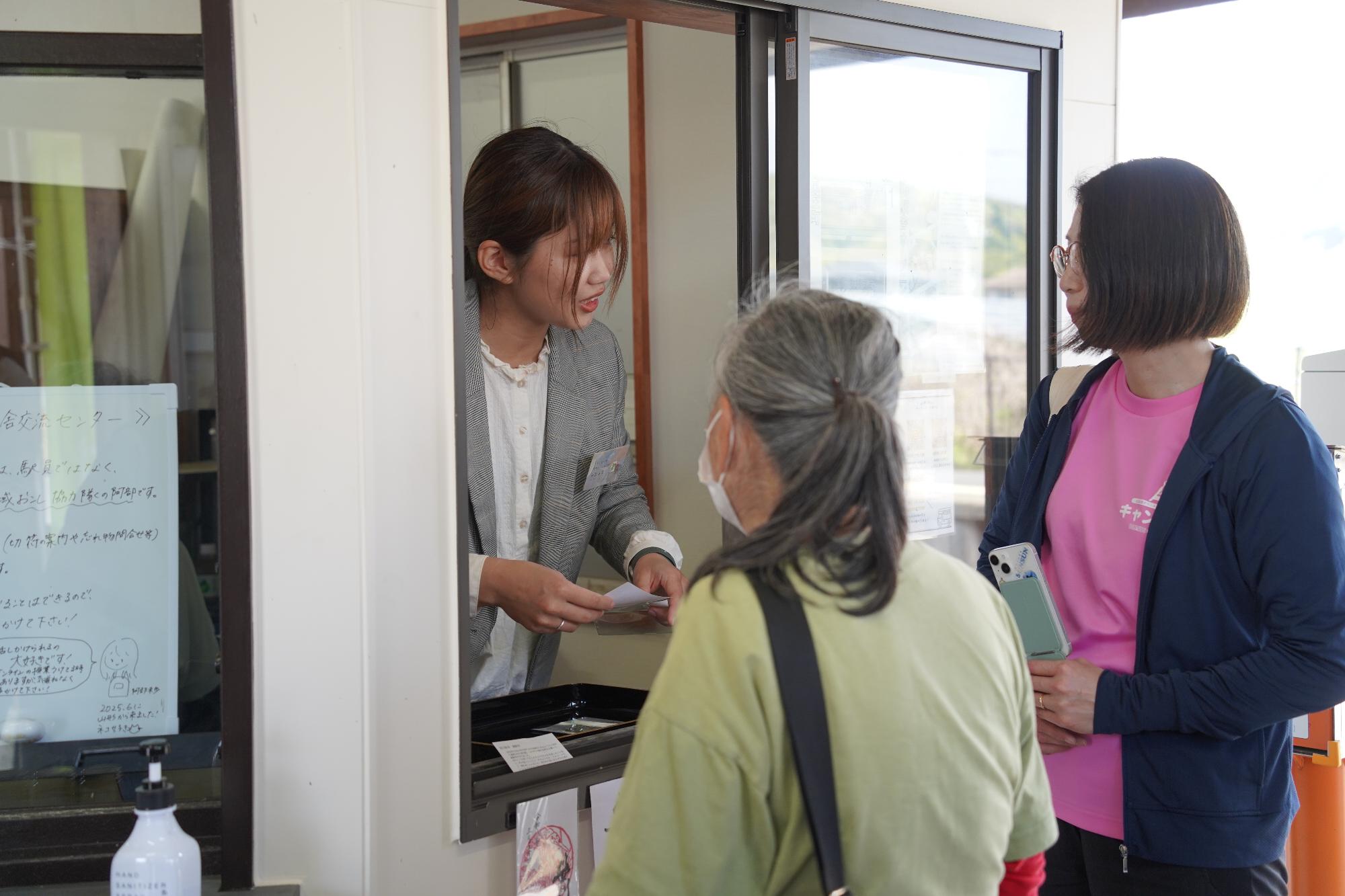 地域おこし協力隊阿部隊員が笹川駅で御駅印を販売している写真