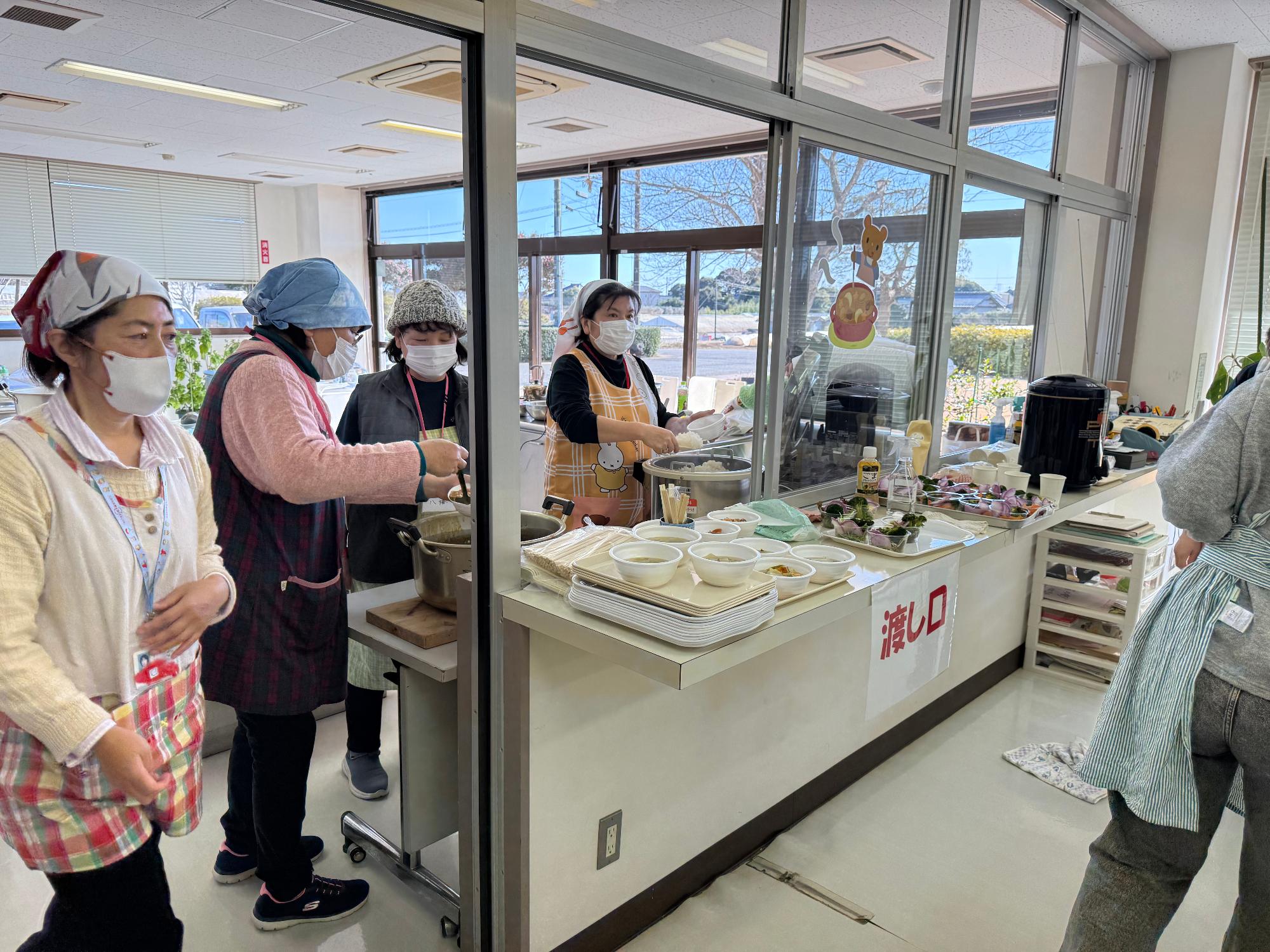 東庄ふれあいセンターで行われたみんなの食堂でスタッフが食事を提供している様子