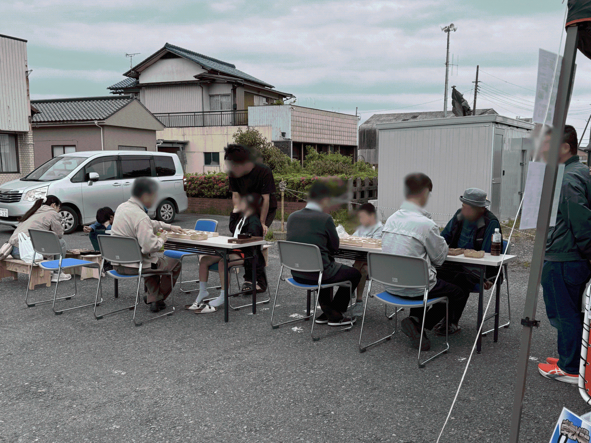 駅前のスペースに机を並べ、将棋を楽しむ人たちの写真