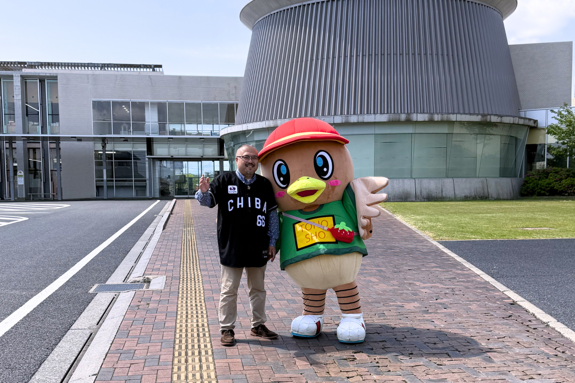 東庄町役場前でコジュリンくんと並んでポーズをとる市野さん