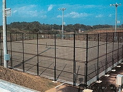 金網フェンスに囲まれた、テニスコートの写真
