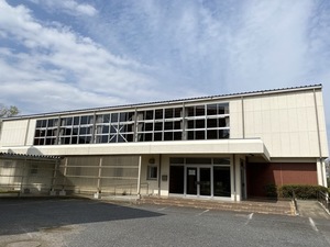 白壁、2階の中央付近がガラス窓の東庄町民神代体育館の外観写真