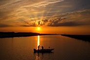 1隻の船が夕日の海をバックに映したサンセット写真