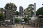 緑の木々の中、4体の石碑が建てられている天保水滸伝遺跡の写真