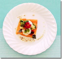 白いお皿にスモークサーモンと春野菜マリネが盛り付けられ、香草が添えられている写真