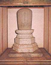 大きな台座に文字が書かれた墓石が乗っている石製の鉄牛和尚の墓の写真